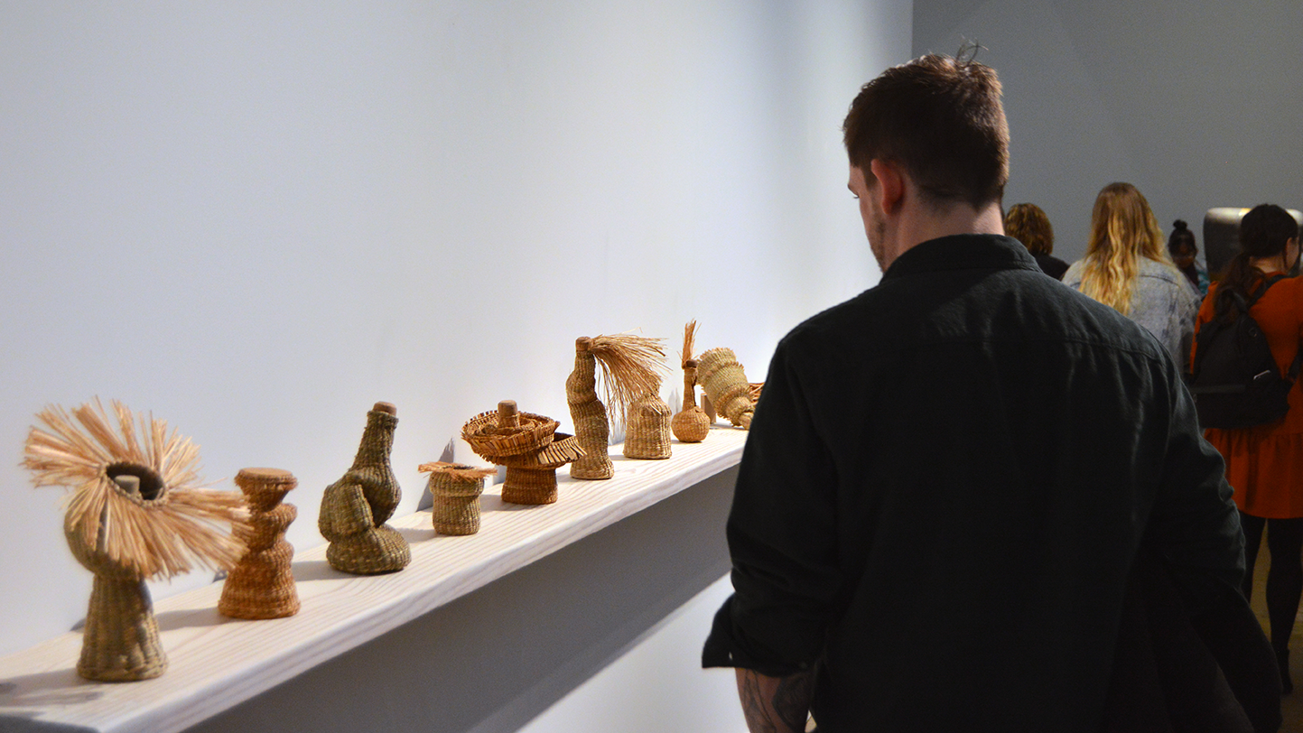 A man observes a row of hand-made baskets